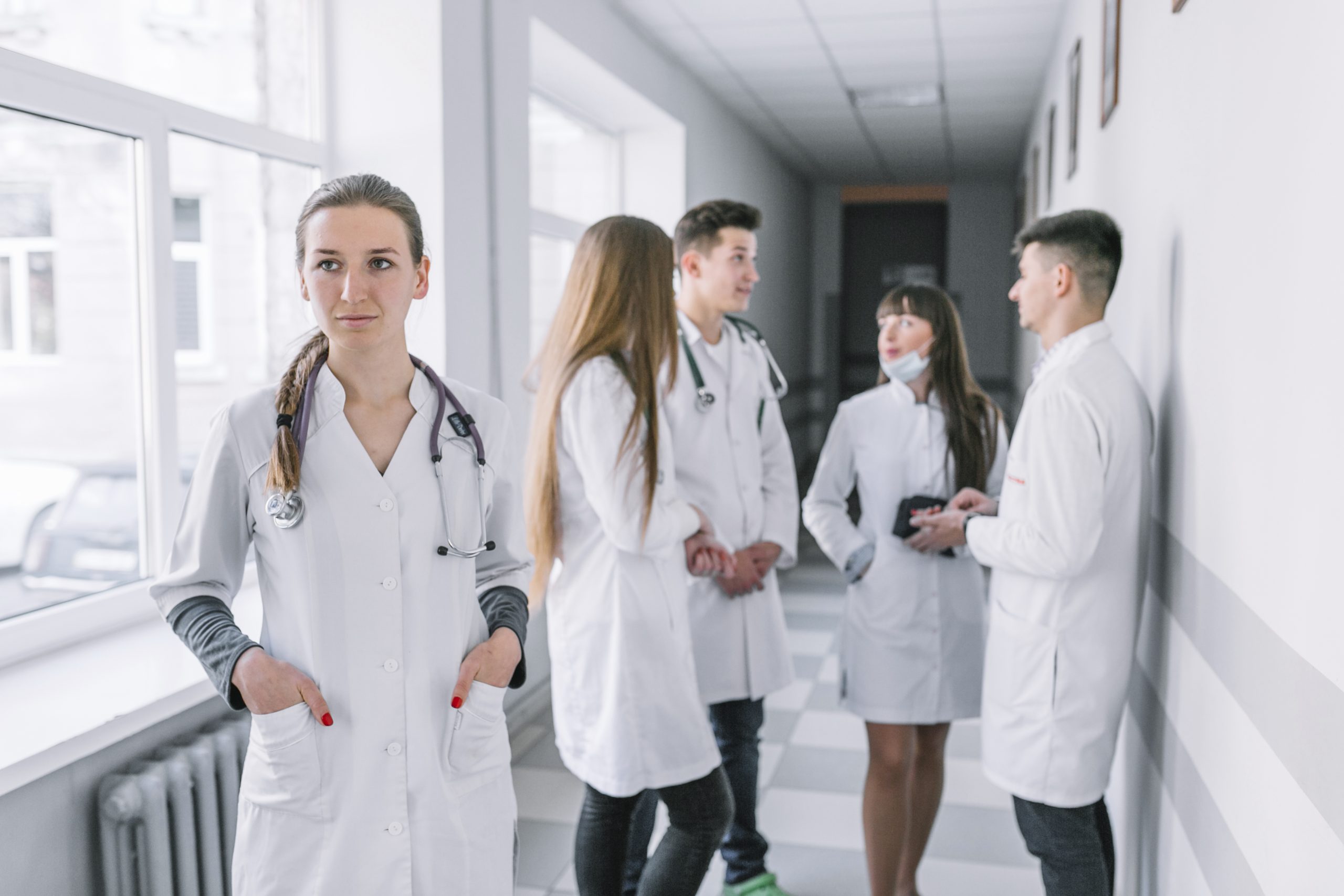 young-medic-standing-hallway-with-colleagues